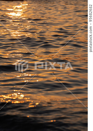 Ripple sea ocean water surface with golden sunset light. Sea wave close up Ripple sea ocean water surface with golden sunset light. Sea wave close up 95682682