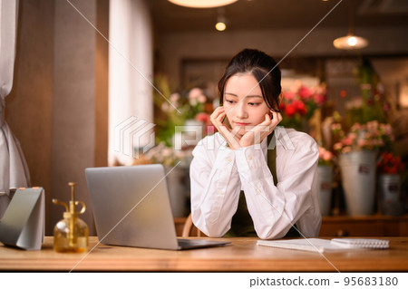 Time for flower shop employees to do office work on a computer 95683180