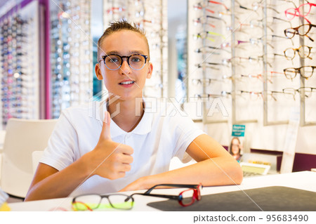Male client trying on new spectacles in medical shop Male client trying on new spectacles in medical shop 95683490