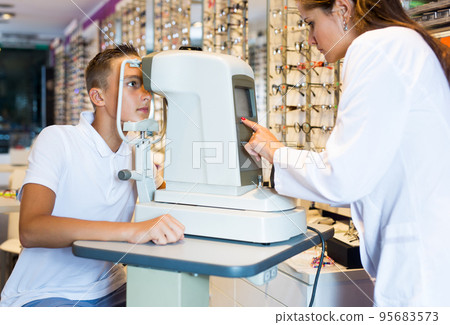 Female optometrist testing eyesight of boy 95683573