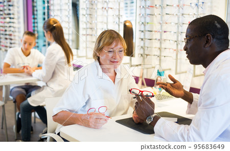 African American ophthalmologist consulting elderly woman African American ophthalmologist consulting elderly woman 95683649