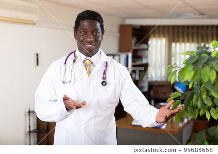 Smiling african american doctor welcoming to medical office Smiling african american doctor welcoming to medical office 95683668