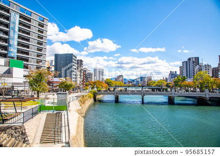 A view of the city area on both sides of the Enko River to the east from the Ekimae Ohashi Bridge on the south side of Hiroshima Station. You can see the golden mountain in the distance. Hiroshima 95685157
