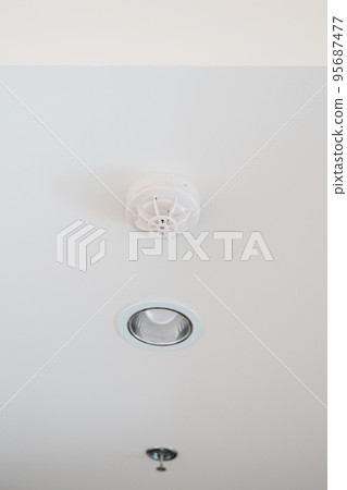Smoke sensor detector mounted on roof in home or apartment. Safety and conflagration security concept 95687477