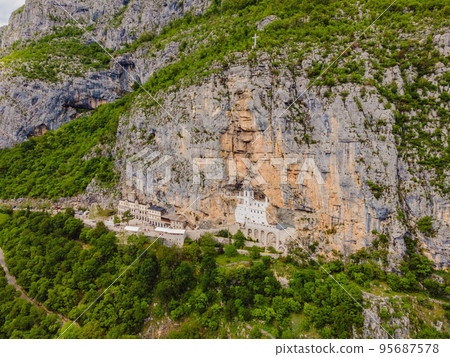 Monastery of Ostrog, Serbian Orthodox Church situated against a vertical background, high up in the large rock of Ostroska Greda, Montenegro. Dedicated to Saint Basil of Ostrog 95687578