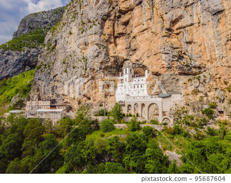 Monastery of Ostrog, Serbian Orthodox Church situated against a vertical background, high up in the large rock of Ostroska Greda, Montenegro. Dedicated to Saint Basil of Ostrog 95687604