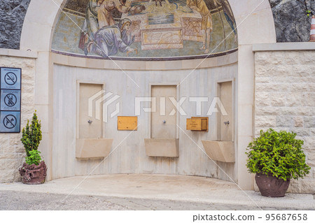 Monastery of Ostrog, Serbian Orthodox Church situated against a vertical background, high up in the large rock of Ostroska Greda, Montenegro. Dedicated to Saint Basil of Ostrog 95687658
