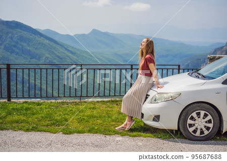 Woman tourist on background of Blue river running through green valley toward distant mountains. Beautiful mountains of Montenegro and the river Cievna 95687688