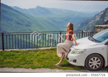 Woman tourist on background of Blue river running through green valley toward distant mountains. Beautiful mountains of Montenegro and the river Cievna Woman tourist on background of Blue river running through green valley toward distant mountains. Beautiful mountains of Montenegro and the river Cievna 95687726