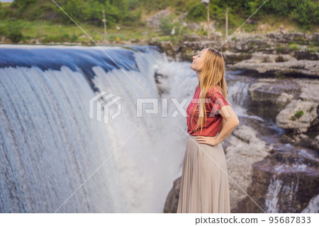 Woman tourist on background of Picturesque Niagara Falls on the river Cievna. Montenegro, near Podgorica. Travel around Montenegro concept Woman tourist on background of Picturesque Niagara Falls on the river Cievna. Montenegro, near Podgorica. Travel around Montenegro concept 95687833