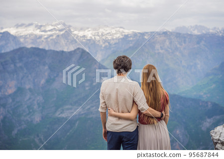 Man and woman happy couple tourists on background of Breathtaking panoramic view of the Grlo Sokolovo gorge in Montenegro. In the foreground is a mountain, the flat side of which forms a cliff, and 95687844