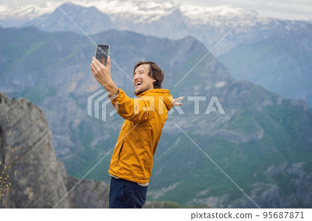 Man tourist on background of Breathtaking panoramic view of the Grlo Sokolovo gorge in Montenegro. In the foreground is a mountain, the flat side of which forms a cliff, and the ridge is overgrown 95687871