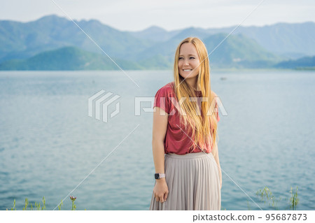 Woman tourist on background of National Park Skadar Lake. Montenegro. Skadar lake. Dawn. View from above. The largest lake in the Balkans. Mountains of the Dinaric Highlands. Swampy shores and Woman tourist on background of National Park Skadar Lake. Montenegro. Skadar lake. Dawn. View from above. The largest lake in the Balkans. Mountains of the Dinaric Highlands. Swampy shores and 95687873