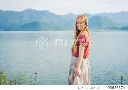 Woman tourist on background of National Park Skadar Lake. Montenegro. Skadar lake. Dawn. View from above. The largest lake in the Balkans. Mountains of the Dinaric Highlands. Swampy shores and Woman tourist on background of National Park Skadar Lake. Montenegro. Skadar lake. Dawn. View from above. The largest lake in the Balkans. Mountains of the Dinaric Highlands. Swampy shores and 95687874