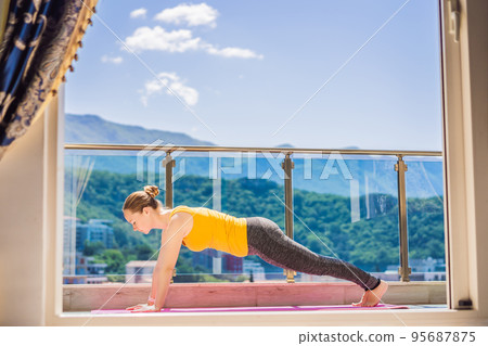 Beautiful woman doing yoga outdoors on a rooftop terrace Beautiful woman doing yoga outdoors on a rooftop terrace 95687875
