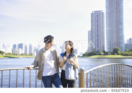 Young couple strolling along the waterfront Young couple strolling along the waterfront 95687910