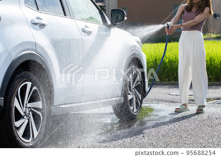 A woman washing a car car wash A woman washing a car car wash 95688254