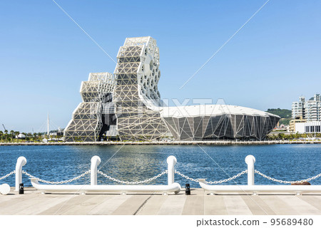 Building view of Kaohsiung Music Center in Port of Kaohsiung, Taiwan. The white hexagonal building structure on the shore of love pier. 95689480
