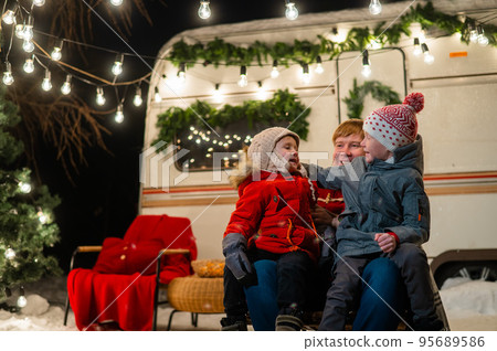 Caucasian man and two sons celebrate Christmas in a mobile home. Caucasian man and two sons celebrate Christmas in a mobile home. 95689586