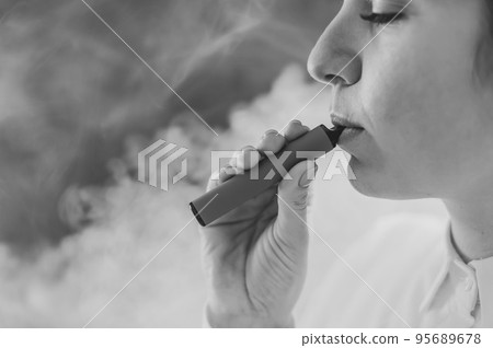 The doctor holds a smartphone with a black screen on a white background. Black and white photo. 95689678