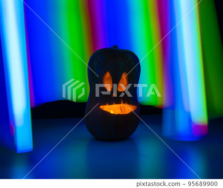 Jack-o-lantern glow in the dark against the backdrop of a rainbow. Halloween decoration. 95689900