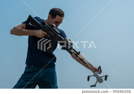 Caucasian man caught a drone shoots from a rifle. Air espionage. Caucasian man caught a drone shoots from a rifle. Air espionage. 95690208