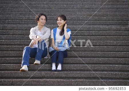 年輕夫婦坐在樓梯上交談 年輕夫婦坐在樓梯上交談 95692853