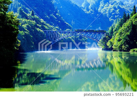Tadami Line Kiha E120 series train crossing the first Tadami River bridge in early autumn (Mishima Town, Fukushima Prefecture, September) 95693221