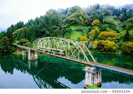 Tadami Line Kiha E120 series train crossing the No. 5 Tadami River Bridge in early autumn (Kanayama Town, Fukushima Prefecture, October) 95693284