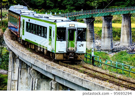 A special autumn train "Tadami Line Mankoku-go" crossing the Kanotsu River Bridge (Tadami Town, Fukushima Prefecture, October) 95693294