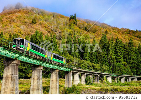 Tadami Line Kiha E120 series train crossing the Kanotsu River Bridge in early autumn (Tadami Town, Fukushima Prefecture, October) 95693712