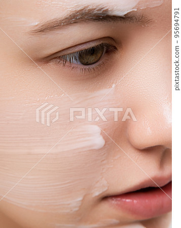 Beautiful woman applying moisturizer cream on her Beautiful woman applying moisturizer cream on her 95694791