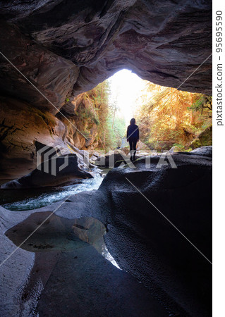 Adventurous woman standing inside a cave. Adventure Travel. Little Huson Caves Park 95695590