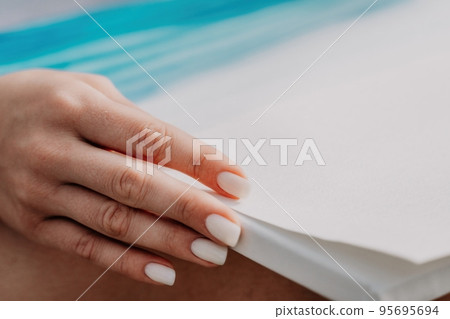 Unrecognizable woman's hands holding her own sea beach scenery watercolor painting. Amateur painter. Creative female artist drawing the picture at the beach. Art, creativity and inspiration concept. 95695694