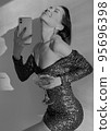Mobile photo of a young woman with a glass of champagne 95696398