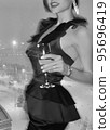 Mobile photo of a young woman with a glass of champagne 95696419