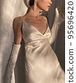 Mobile photo of a young woman with a glass of champagne 95696420