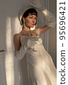 Mobile photo of a young woman with a glass of champagne 95696421