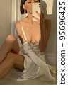 Mobile photo of a young woman with a glass of champagne 95696425