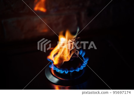 Energy crisis after Russias invasion of Ukraine. Increase the cost of supply, payment for natural gas. Paper banknote burns like fuel on gas stove burner in the kitchen Energy crisis after Russias invasion of Ukraine. Increase the cost of supply, payment for natural gas. Paper banknote burns like fuel on gas stove burner in the kitchen 95697174