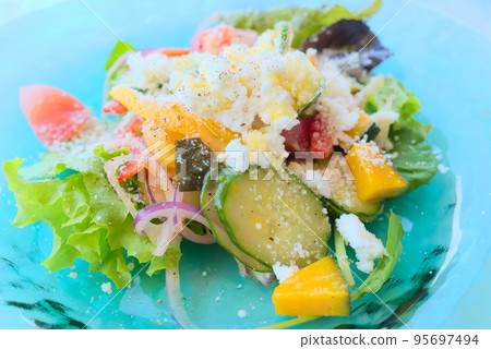 A healthy salad with lots of vegetables sprinkled with grated cheese A healthy salad with lots of vegetables sprinkled with grated cheese 95697494