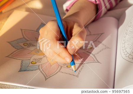 Female painting mandalas antistress page to combat stress. Relaxing hobby mental wellbeing and art therapy. Woman paints sketch, meditative process of coloring pages. Self expression by art  95697565