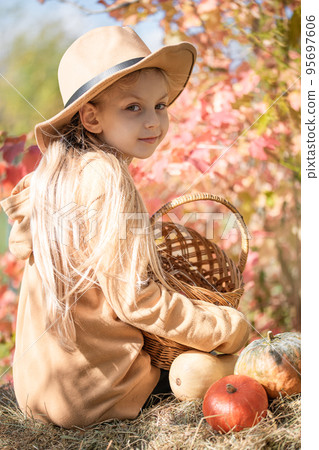 Girl in the hay with pumpkins Girl in the hay with pumpkins 95697606