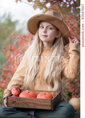Girl in the hay with pumpkins Girl in the hay with pumpkins 95697607
