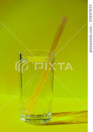 Reusable glass Straws in Glass with water on yellow background Eco-Friendly Drinking Straw Set with cleaning brush. Zero waste, plastic free concept 95697655