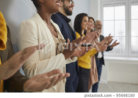Diverse businesspeople clap hands at business meeting Diverse businesspeople clap hands at business meeting 95698180