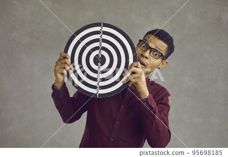 Young african american shocked man with dartboard over grey studio wall 95698185