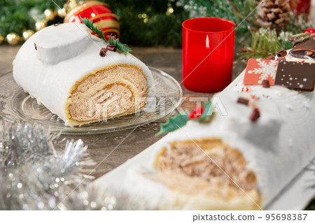 White chocolate yule log cake with christmas lights 95698387