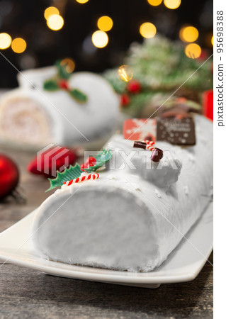 White chocolate yule log cake with christmas lights 95698388
