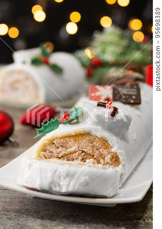 White chocolate yule log cake with christmas lights 95698389